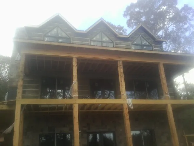Dormers and porch framing on a large log home under construction — Roof Coating work by our crew in Chillicothe