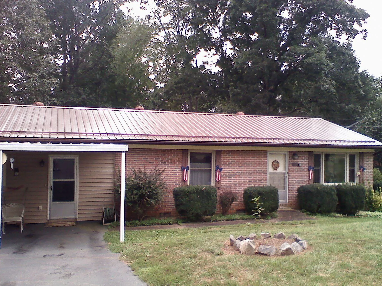 Bronze metal roof and carport on a brick ranch home — Roof Repair work by our crew in Chillicothe